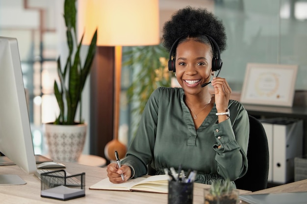 Listo para tomar su llamada. Retrato recortado de una atractiva joven empresaria que usa un auricular para hacer llamadas mientras está sentada en su oficina.