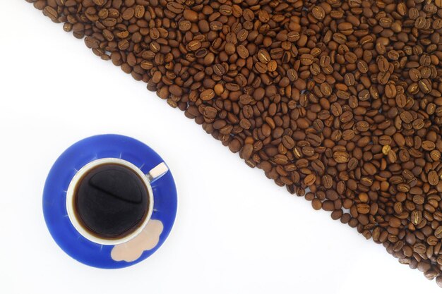 listras de grãos de café isoladas em fundo branco Quadro com grãos de café e xícara de café azul