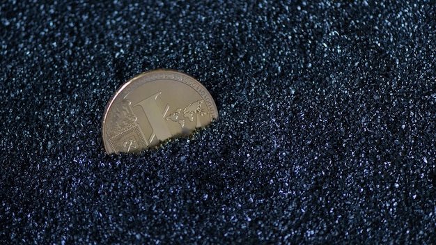 Litecoin em grânulos cintilantes azuis, areia. dinheiro eletrônico