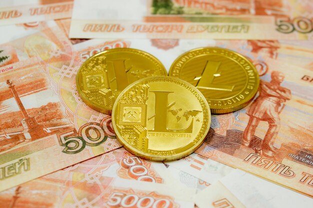 Litecoin moeda criptomoeda em notas de 5000 rublos russos close-up. Criptomoeda Golden LTC.