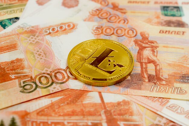 Litecoin moeda criptomoeda em notas de 5000 rublos russos close-up. Criptomoeda Golden LTC.