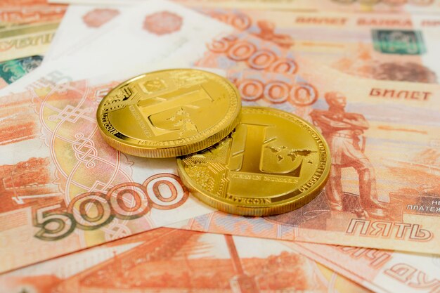 Litecoin moeda criptomoeda em notas de 5000 rublos russos close-up. Criptomoeda Golden LTC.