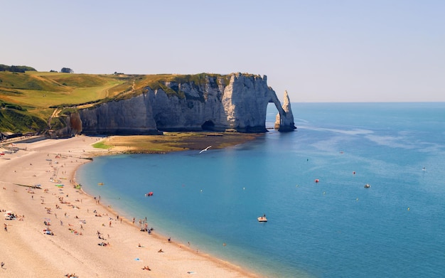 Litoral de Etretat com arco de pedra natural de penhascos de giz branco e a praia Normandia França