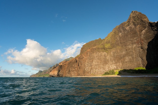 Litoral de Na Pali retirado do cruzeiro ao pôr do sol ao longo da costa de Kauai