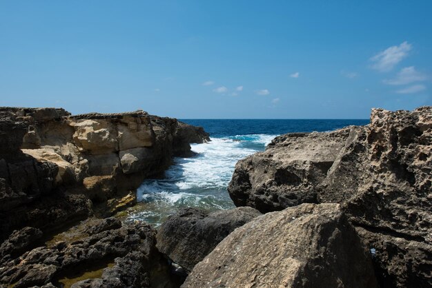 Litoral rochoso e mar Buraco azul e a janela azul colapsada na Baía de Dwejra Gozo Malta