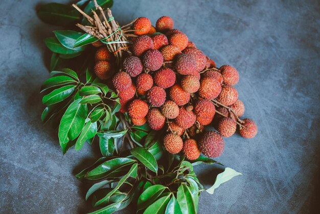 Litschi-Frucht mit grünem Blatt auf schwarzem Hintergrund frische reife Litschi vom Litschi-Baum bei tropischen Früchten Thailand im Sommer