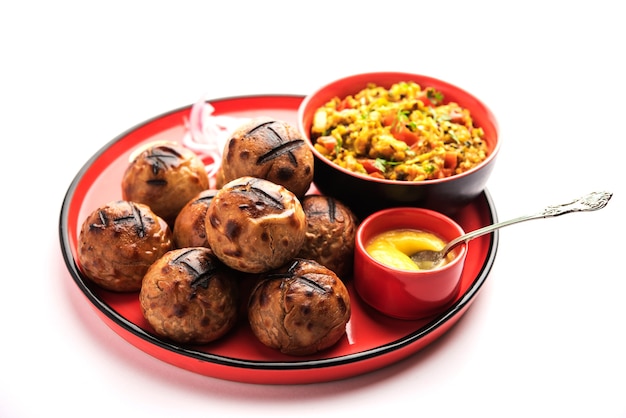 Foto litti chokha, es una comida completa originada en el estado indio de bihar. popular en jharkhand y uttar pradesh. servido en un plato con desi ghee