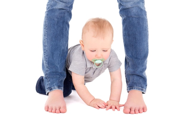 Little Baby Boy Toddler y las piernas de la madre aislado sobre fondo blanco.