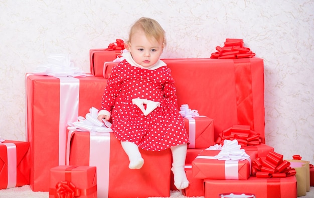 Little Baby Mädchen spielen in der Nähe von Stapel von Geschenkboxen Geschenke für Kind erste Weihnachten Feiern Sie erste Weihnachten Baby erste Weihnachten einmal im Leben Ereignis Teilen Sie die Freude am ersten Weihnachten des Babys mit der Familie