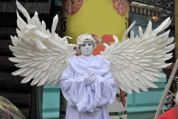 Live-Wiederherstellung der Weihnachtskrippe Schauspieler, der eine Statue eines Engels nachahmt