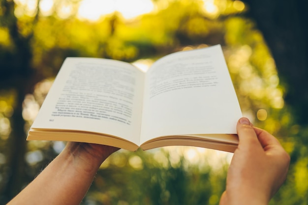 Livro aberto em um fundo de pôr-do-sol Ler estudando na escola Ler um livro ao ar livre