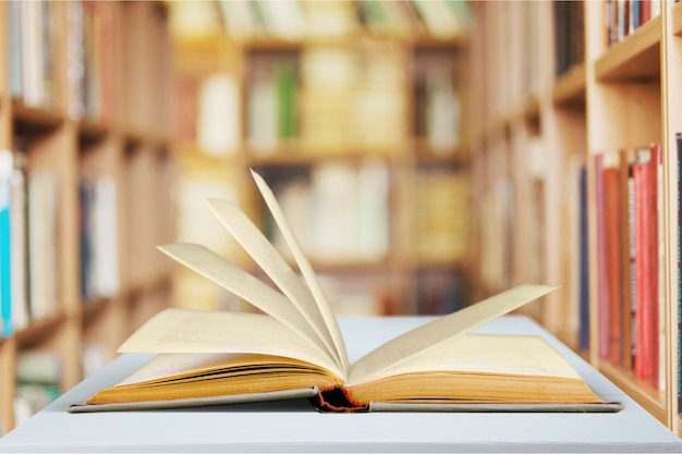 Livro aberto na velha mesa de madeira.