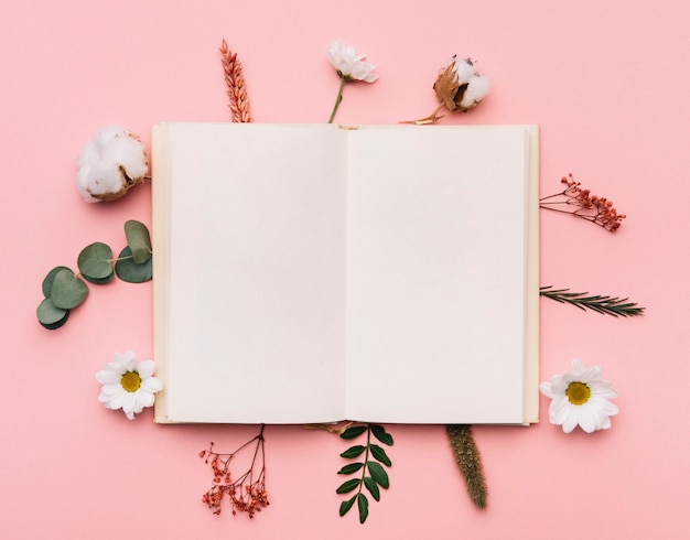 Foto livro aberto sobre elementos botânicos