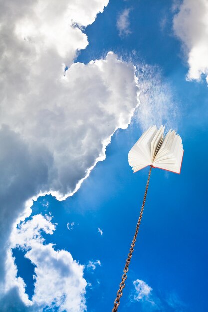 Livro amarrado na corrente sobe no céu escuro