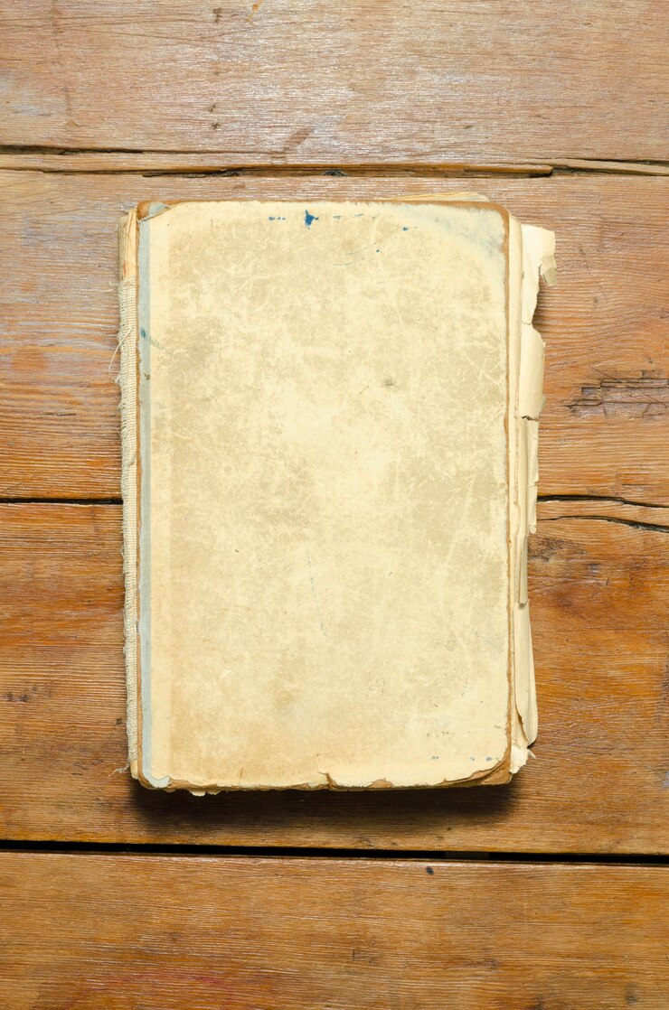 Livro antigo detalhado com capa em branco no tampo da mesa de madeira vintage