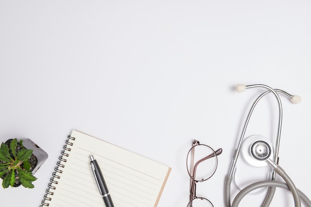 Livro branco em branco do caderno com caneta de tinta preta, estetoscópio, caneta e bloco de receitas em branco. Remédio ou farmácia. Formulário médico vazio pronto para ser usado. Tecnologia da informação médica moderna.