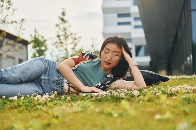 Livro de leitura A jovem asiática está ao ar livre durante o dia