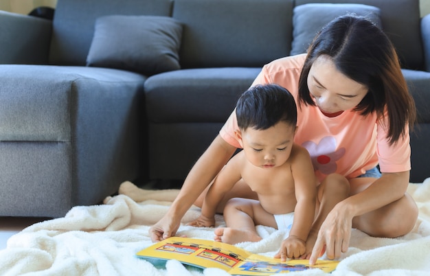 Livro de leitura asiática da mãe com seu filho