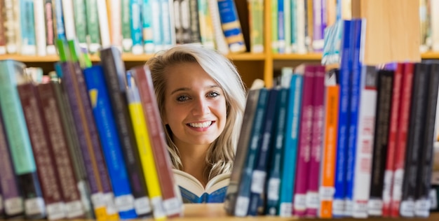 Livro de leitura de estudante sorridente na biblioteca