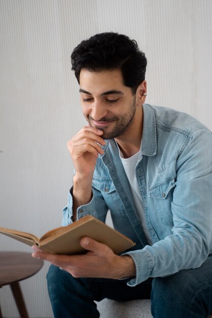 Livro de leitura de homem sorridente de tiro médio