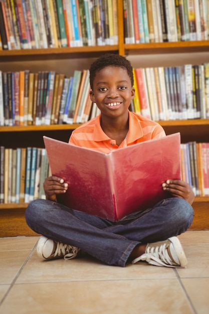 Livro de leitura de menino bonito na biblioteca