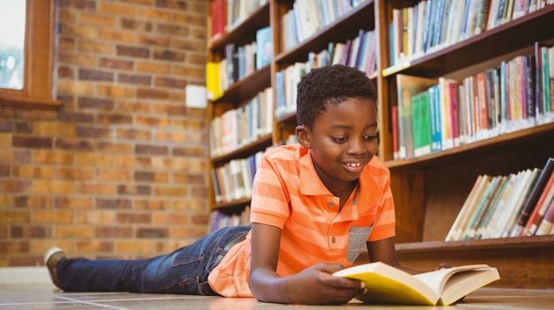 Livro de leitura de menino bonito na biblioteca