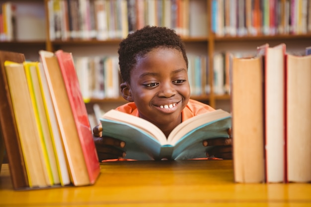 Livro de leitura de menino bonito na biblioteca