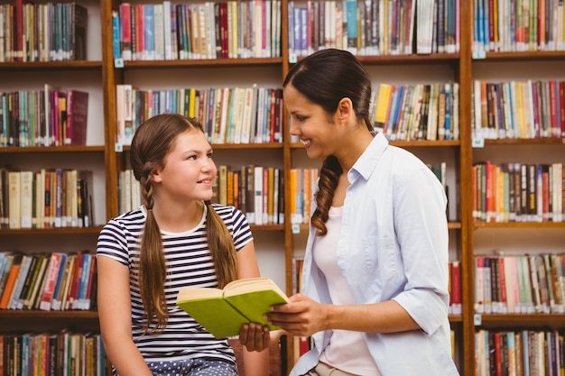 Livro de leitura de professor e menina na biblioteca