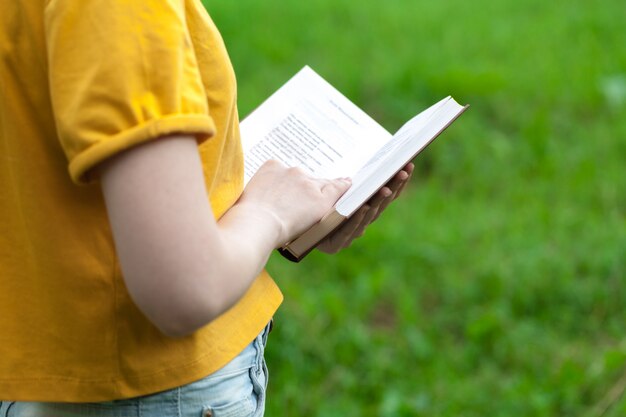 Livro de leitura feminina jovem no parque de verão