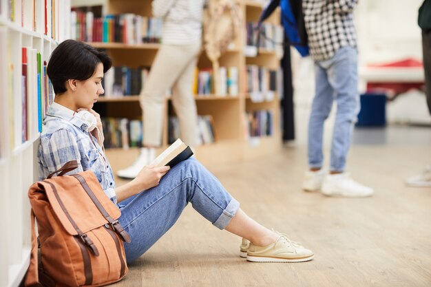 Livro de leitura pensativo do estudante na loja