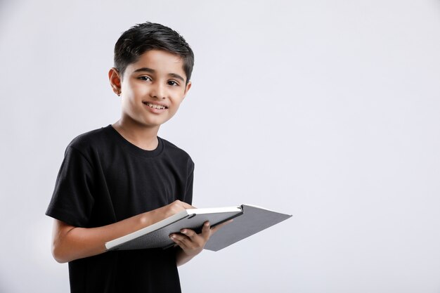 Livro de leitura pequeno indiano / asiático menino bonito isolado