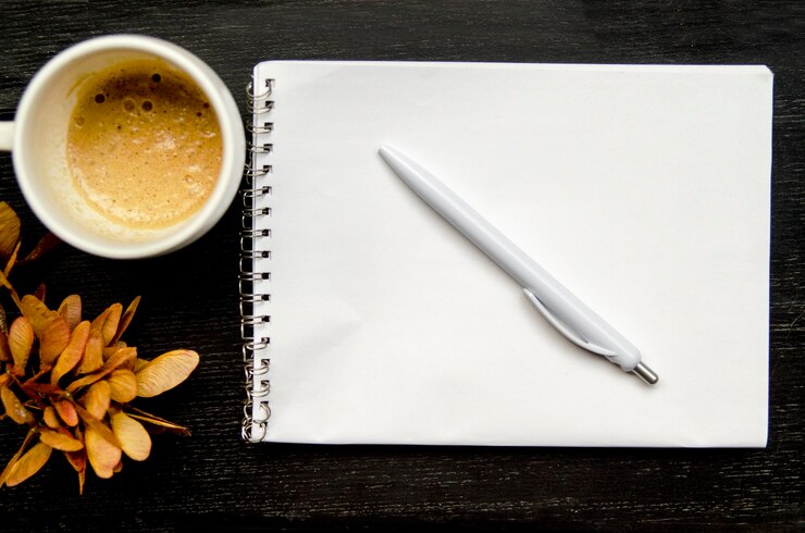Foto livro de nota de papel em branco com lápis e café na mesa preta