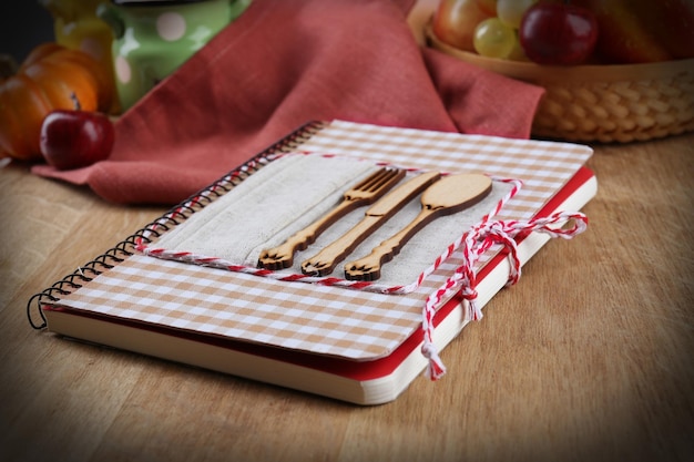 Livro de receitas na cozinha em fundo de madeira