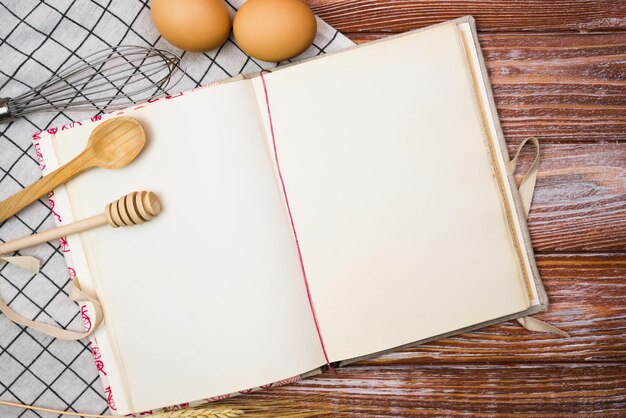 Foto livro de receitas vintage em branco e na mesa de madeira da cozinha closeup lugar para texto vista superior