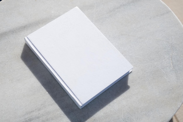 livro em branco para design de maquete na mesa de mármore à beira da piscina