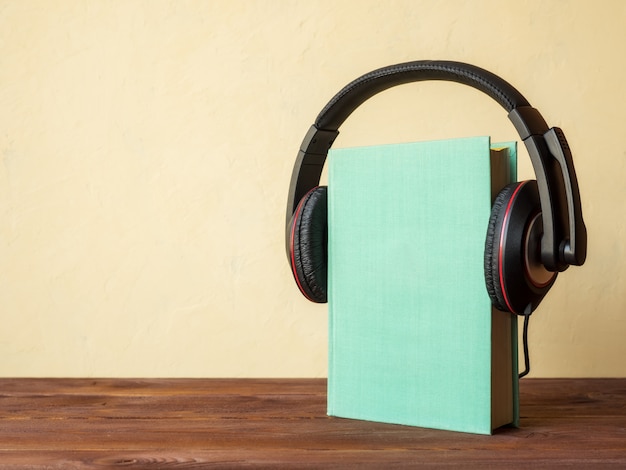 Livro sobre a mesa com fones de ouvido