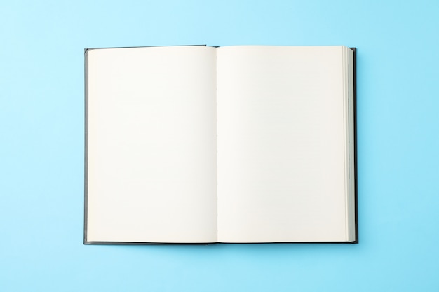 Foto livro vazio aberto sobre fundo azul, vista superior livro vazio aberto sobre fundo azul, vista superior