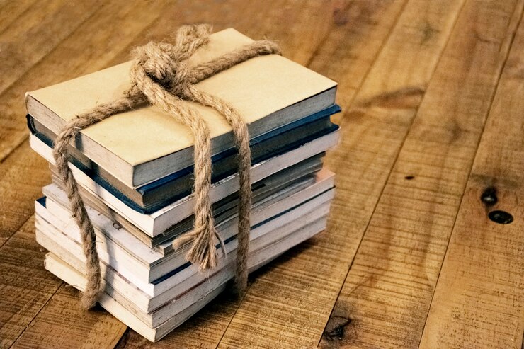 Foto livro velho amarrado com uma corda grossa em uma mesa de madeira