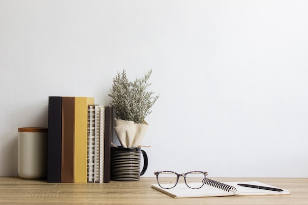Livros caderno café e flor sobre a mesa de madeira