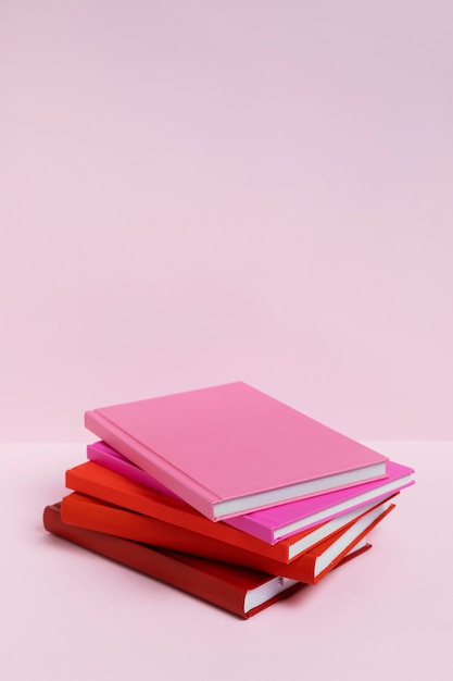 Livros de ângulo alto com fundo rosa