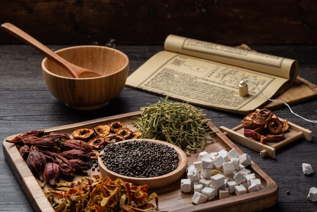 Foto livros de medicina chinesa antiga e ervas na mesa