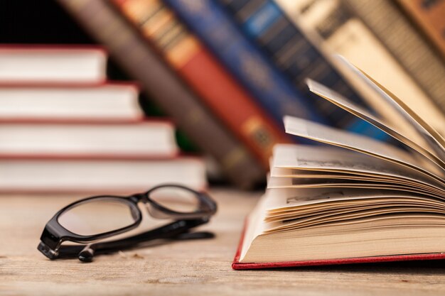 Livros e óculos no fundo da mesa, close-up