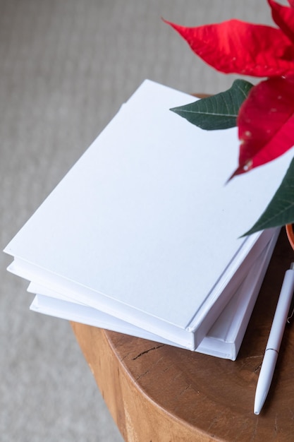 Foto livros em branco com caneta e planta de poinsettia