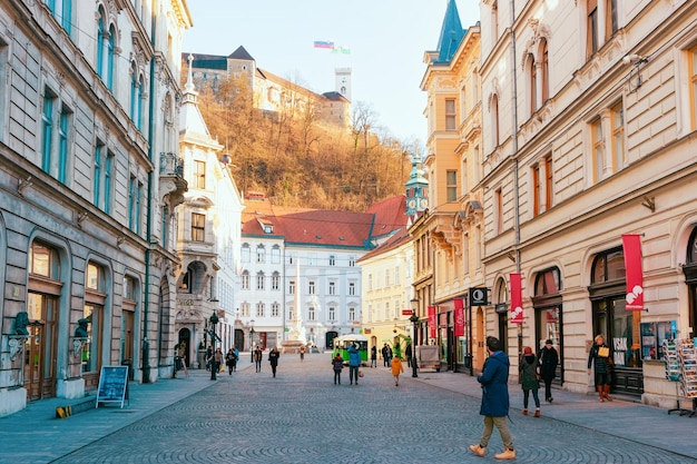 Ljubljana, Slowenien - 15. Januar 2019: Touristen auf Stritarjeva Ulica Street und Stadtbild der Altstadt von Ljubljana mit Schloss, Slowenien, Europa. Leute in der slowenischen Stadtansicht im Winter. Städtische Hauptstadt.