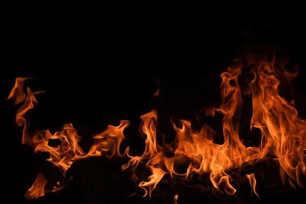 Llama de fuego ardiente y fuego que brilla intensamente sobre fondo negro