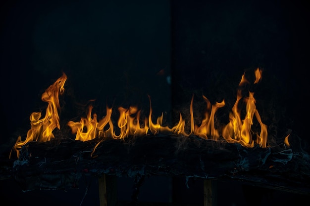 Llama de fuego ardiente y fuego que brilla intensamente sobre fondo negro