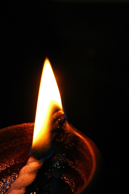 Foto una llama de fuego tranquila de una lámpara de vela que está encendida en la oscuridad con fondo negro