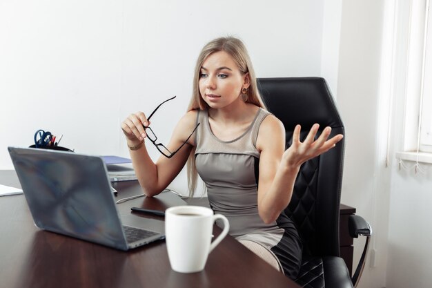 Llamada en línea La mujer de negocios se comunica emocionalmente por videollamada mientras mira la computadora portátil en la oficina de su casa