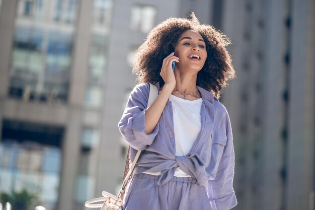 Llamada telefónica. Bastante joven caminando en la calle y hablando por teléfono