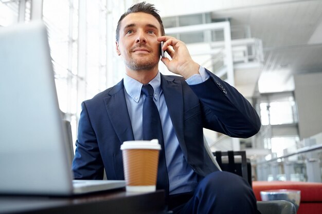 Foto llamada telefónica corporativa o hombre de negocios en un edificio de oficinas para comunicación en red o red b2b sonrisa feliz o gerente con teléfono inteligente para planificar la estrategia de la reunión o hablar en el móvil